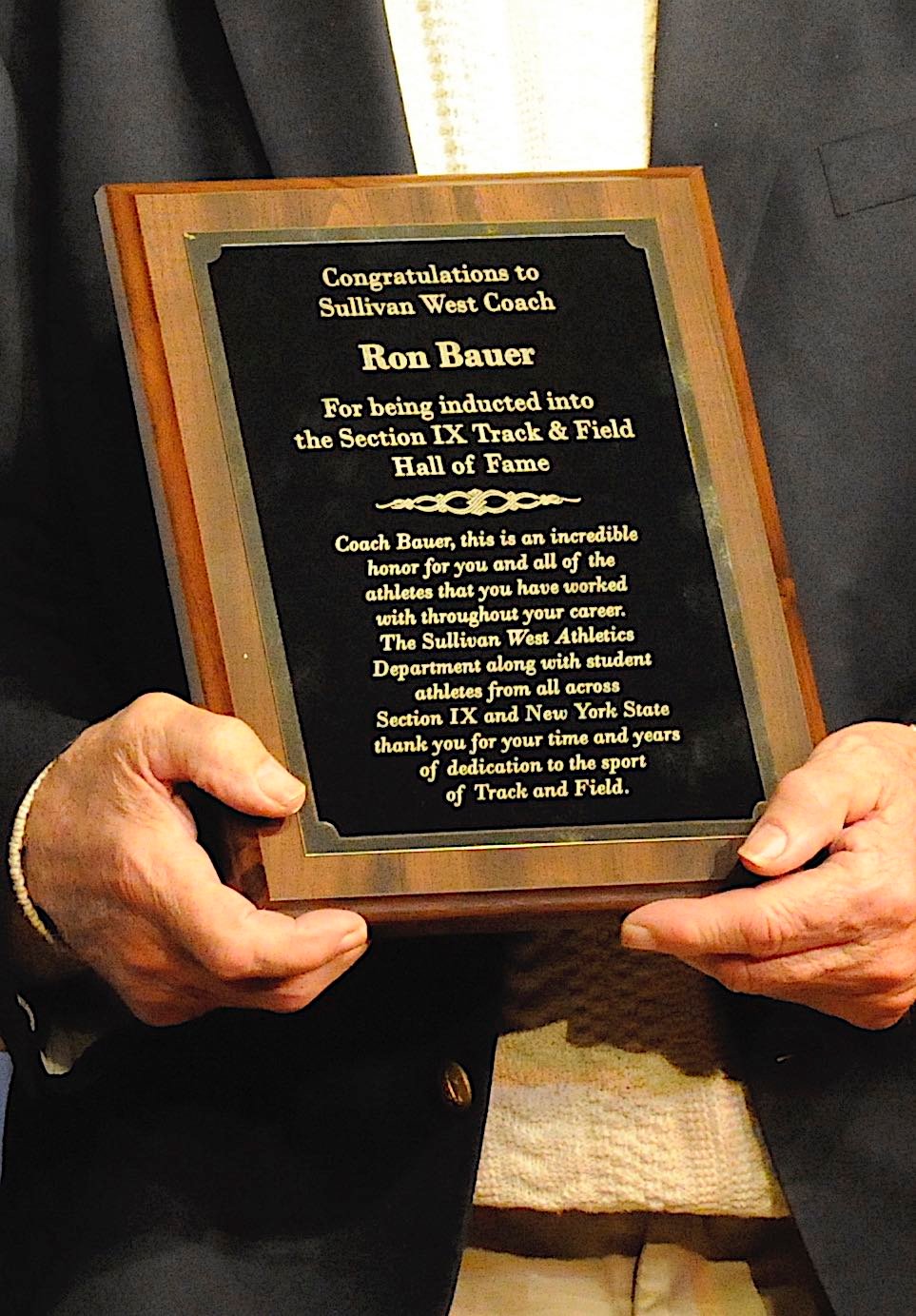Sullivan West coach Ron Bauer holds his plaque.